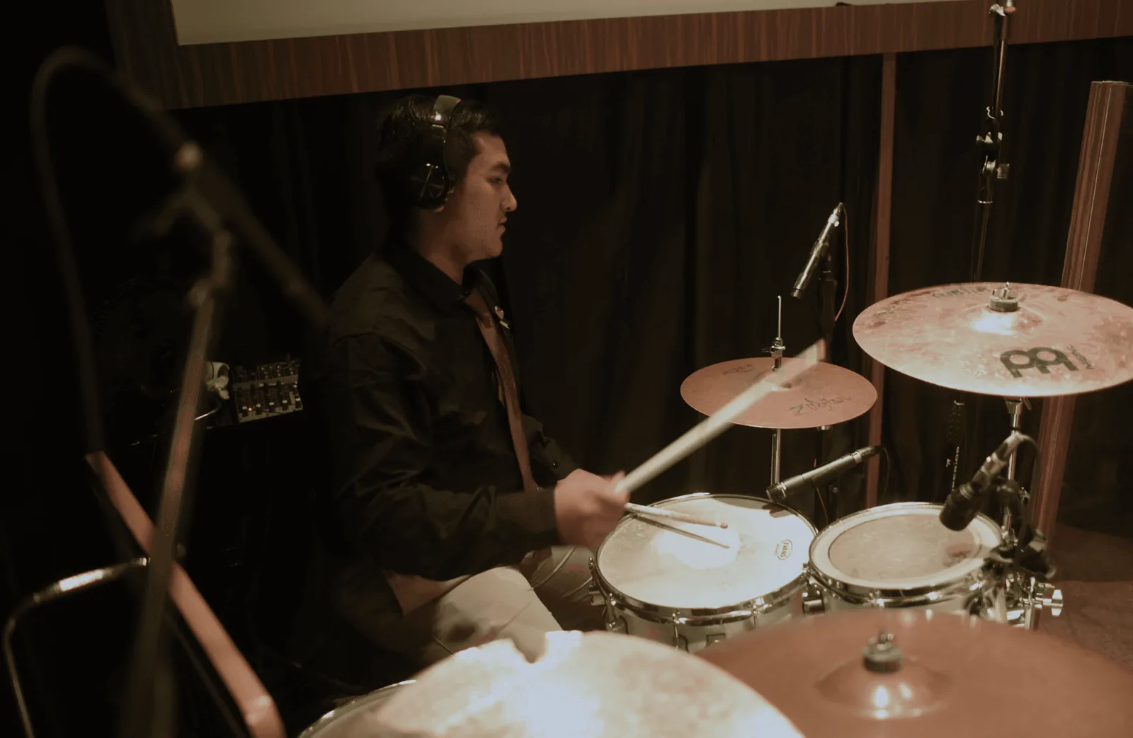Benni playing drums in a studio