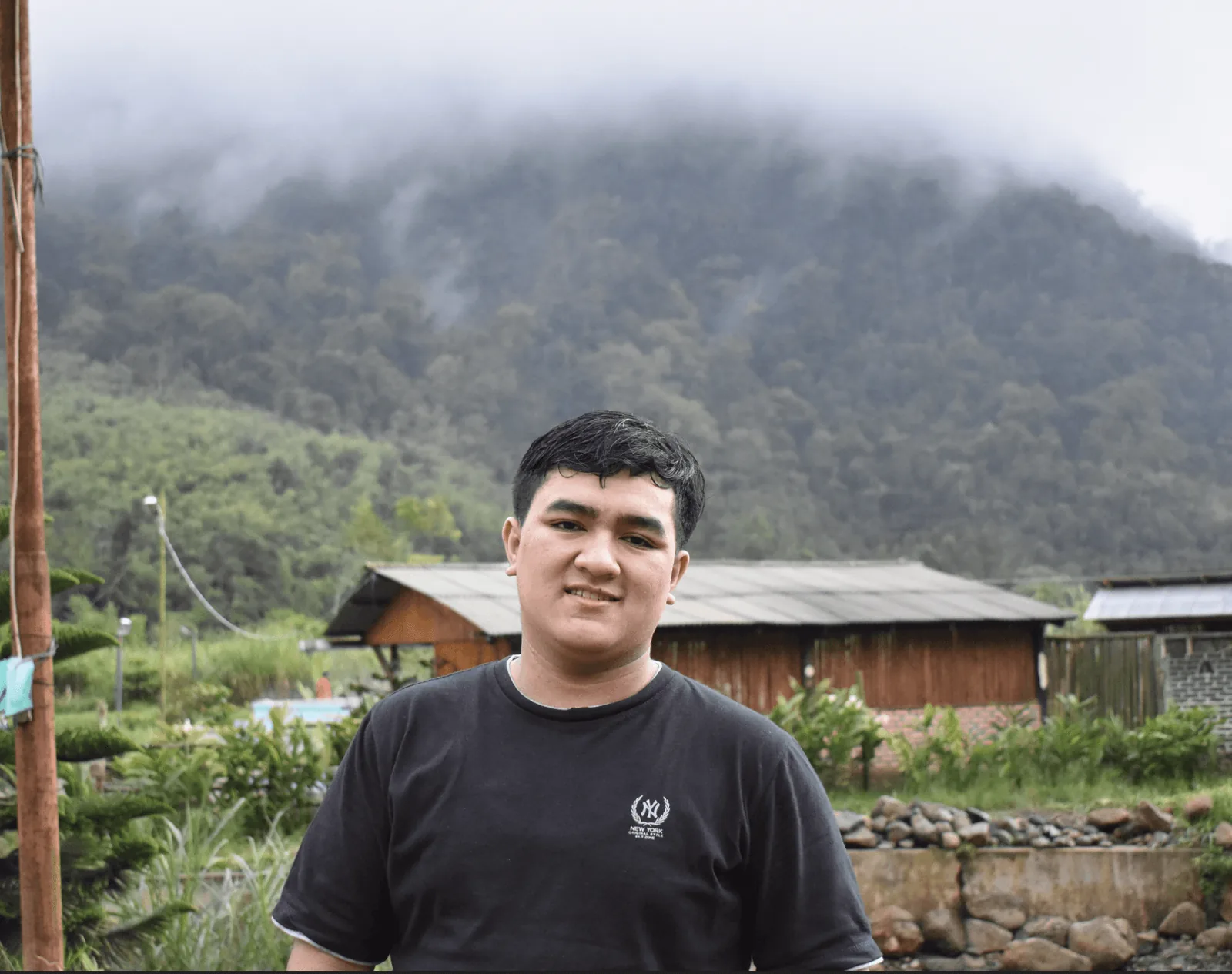Benni standing in front of misty mountains
